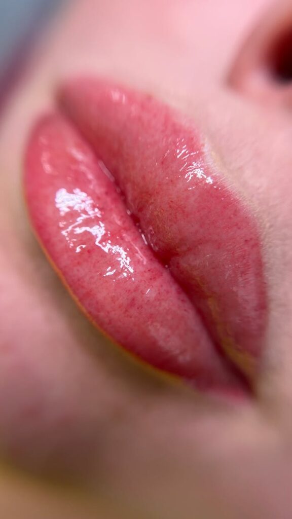 pexels-photo-12829921 A close-up image of glossy pink lips showcasing lip gloss shine.