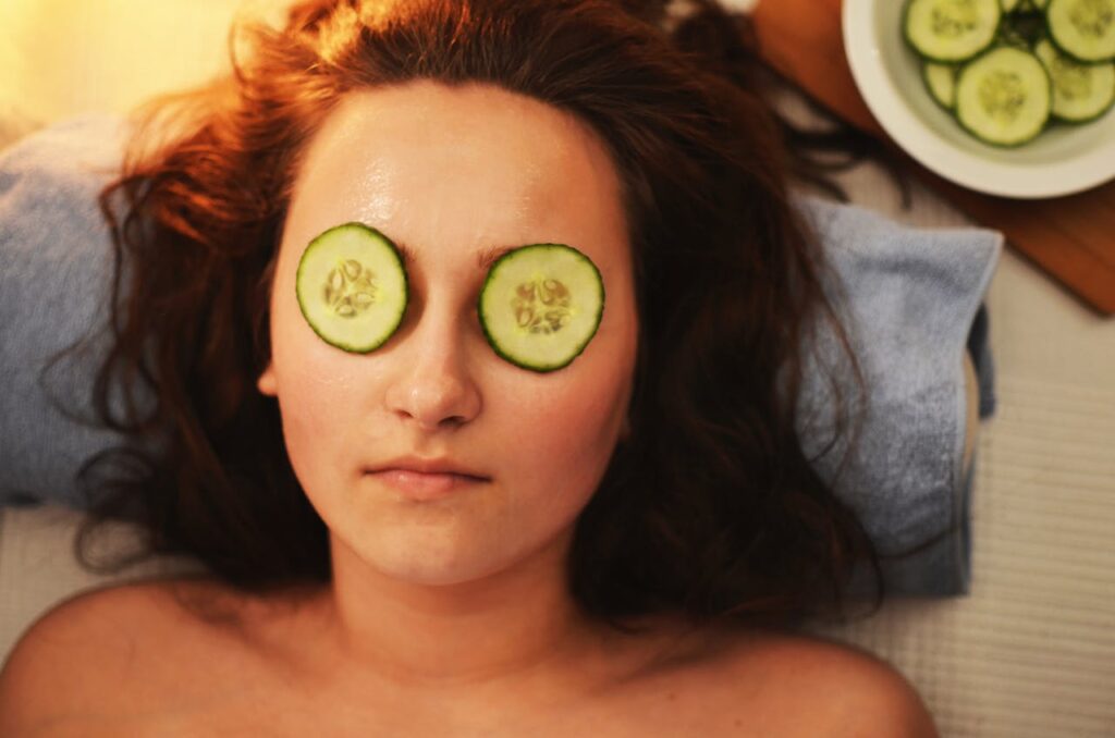 woman-girl-beauty-mask Woman enjoying a relaxing cucumber facial treatment at a spa for skin care and rejuvenation.